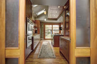 View from dining area through the kitchen to the backyard, showing improved flow and connection between spaces at 8th St Cottage.